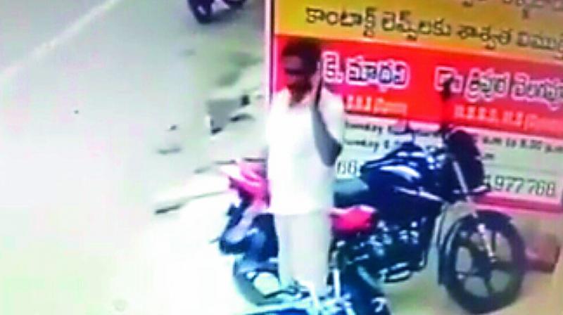 A screen shot of a person stealing helmet from a parked vehicle at Nakkal road in Vijayawada.