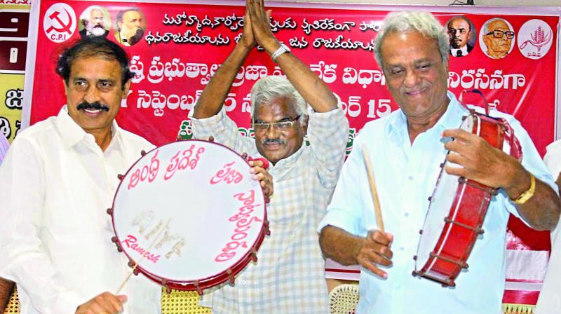 CPI state secretary K. RamaKrishna and CPI senior leader K. Narayana play drums during the party meeting at Guntur on Friday. (Photo: DC)