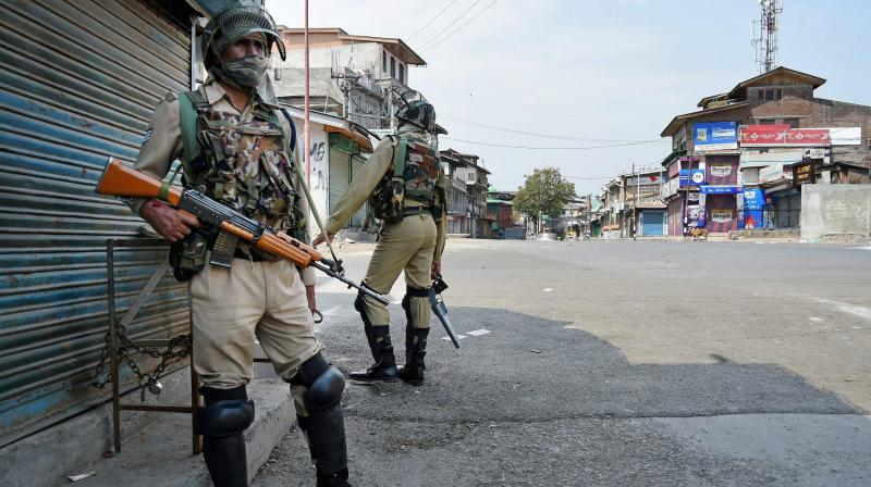 Security personnel patrolling a street during a strike called by separatist groups due to the visit of Home Minister Rajnath Singh, at downtown in Srinagar. (Photo: PTI)