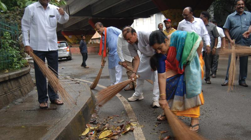 BJP leader and union minister H.N. Ananth Kumar and MLC Tara sweep a prominent street in Bengaluru on Sunday as part of Seva Diwas. (Photo: DC)