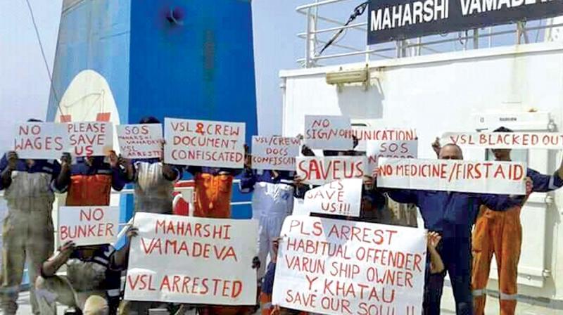 Crew  members of the ship Maharshi Vamadeva stand on the vessels deck holding  placards  calling for help. (Photo by special  arrangement )