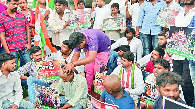Youth Congress activists tonsure their heads, as they sit in protest at the Ambedkar statue near Tankbund against the police brutality towards students of Banaras Hindu University (BHU) on Monday. (Photo: DC)