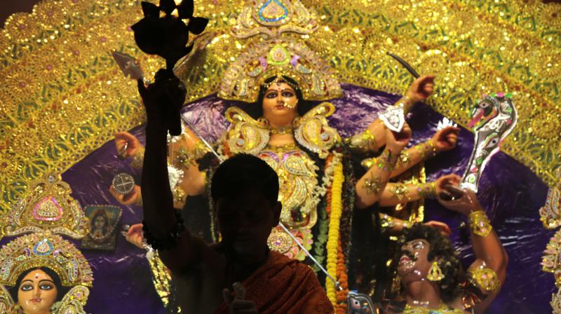 A Hindu priest worships before an idol of goddess Durga with oil lamp during Durga Puja festival in Kolkata, India. (Photo: AP)