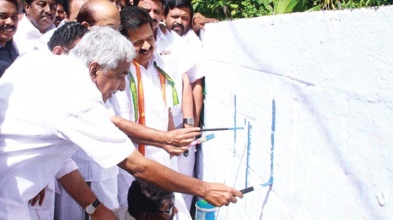 Opposition Leader Ramesh Chennithala and former Chief Minister Oommen Chandy write Padayorukkam, the name of Chennithalas Yatra on a wall at Pattoor in Thiruvananthapuram on Wednesday. Muslim League national general secretary  P. K. Kunhalikutty, MP, and KPCC president M. M. Hassan participated. (Photo: A.V. MUZAFAR)