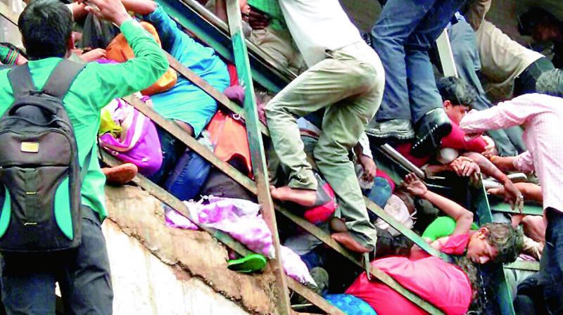 People try to rescue those stuck in the stampede on the Parel-Elphinstone foot over bridge. (Photo: PTI)