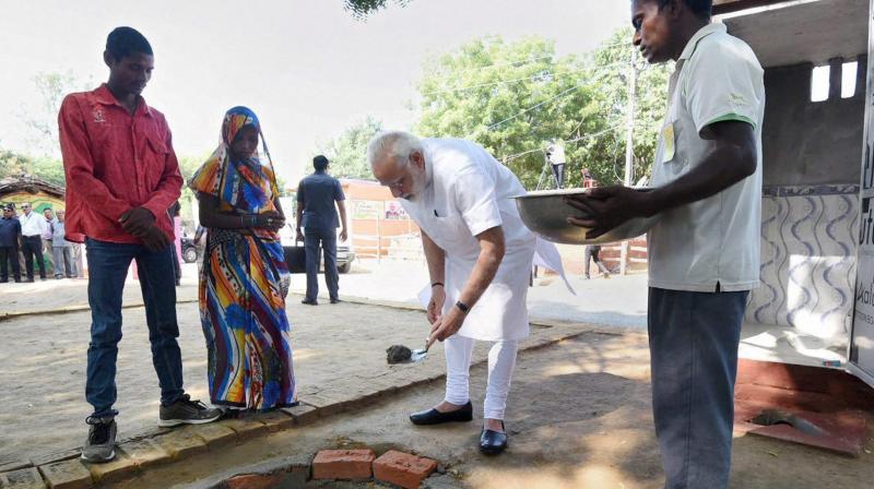 Prime Minister Narendra Modi doing shramdan for the construction of a twin pit toilet, at Village Shahanshahpur, Varanasi, Uttar Pradesh on Saturday. (Photo: PTI)