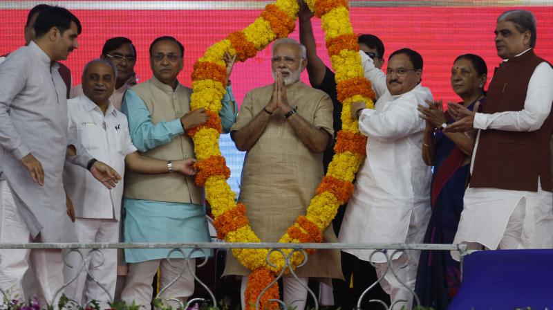 Indian Prime Minister Narendra Modi, center, is garlanded during his visit to his hometown Vadnagar, India. (Photo: AP)