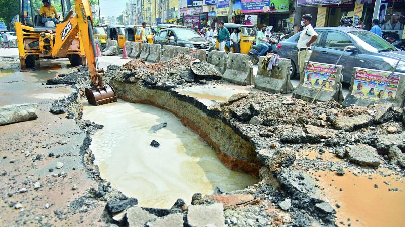 An earthmover was pressed into service after a portion of the road caved in at Usha Mullapudi Road, Kukatpally, following heavy rains on Sunday.  (Photo: S. Surender Reddy)