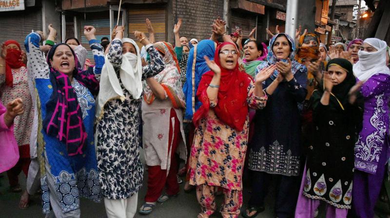 Women shout slogans and block a road during a protest against braid choping incidents in the Valley, at Habakadal in Srinagar. (Photo: PTI)