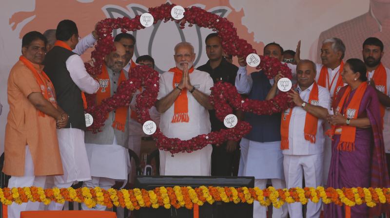 Indian Prime Minister Narendra Modi, center, is garlanded during Gujarat Gaurav Maha Sammelan or Gujarat pride convention in Gandhinagar. (Photo: PTI)