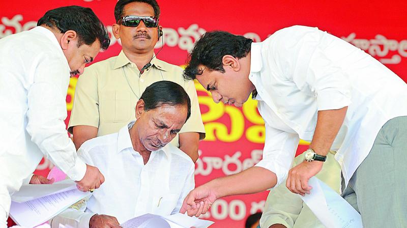 Chief Minister K. Chandrasekhar Rao and IT minister K.T. Rama Rao look at papers at the foundation stone laying ceremony Kakatiya Mega Textile Park in Warangal on Sunday. Warangal mayor Nannapaneni Narender is also seen. As many as 22 companies and institutions signed a memorandum of understanding with the Telangana State Industrial Infrastructure Corporation to invest in the park. Fourteen companies are investing directly in the textile park and eight in other districts. The National Institute of Fashion Technology has agreed to set up a branch in the park.