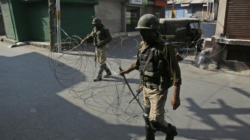 Indian paramilitary soldiers closes a street with a barbwire during a strike called by separatists and restrictions imposed by authorities as a precautionary measure in Srinagar. (Photo: AP)