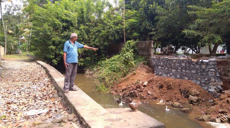 K. Sreedharan Nair, a member of Thettiyar Sahajeevan Swaraj, shows a drainage outlet from TCS compound in Technopark Phase 1, which carries sewage waste and glass wool to Thettiyar.