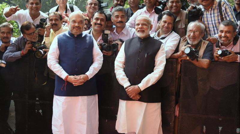 Prime Minister Narendra Modi with BJP President Amit Shah poses for a group picture with photo journalists during the Deepawali Mangal Milan programme at BJP headquarters in New Delhi on Saturday. (Photo: PTI)
