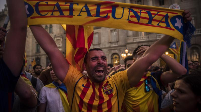 A man holds up a scarf as a crowd of pro-independence supporters gathers in the square outside the Palau Generalitat in Barcelona. (Photo: AP)