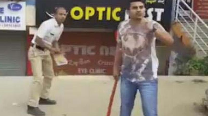 A video grab of Dileep beating up traffic police  constable Bheemashankar with a baseball bat.