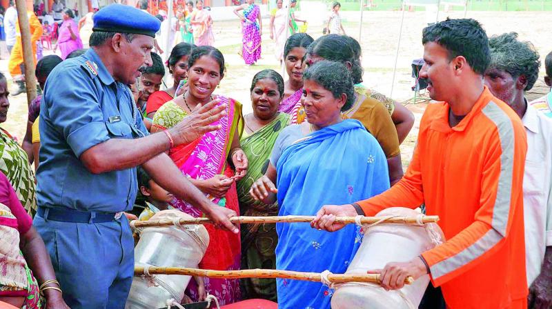 NDRF officials and personnel display safety guards that can be made with available materials to villagers of Ramachandrapuram during a Tsunami mock drill camp at Care School in Maruproluvaripalem village of Guntur district on Friday. (Photo:DC)