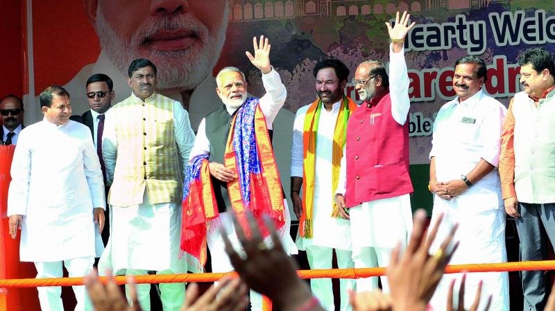 Prime Minister Narendra Modi waves to BJP activists as party MLA C. Ramachandra Reddy, national general secretary P. Muralidhar Rao, BJP Floor leader G. Kishan Reddy, party Telangana unit president K. Laxman look on at a reception arranged at the Begumpet airport in Hyderabad on Tuesday. (Photo: Gandhi)