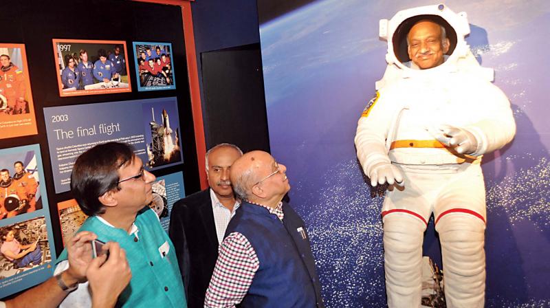 ISRO chief A.S. Kiran Kumar peers through a cutout of a space suit as former ISRO chief K. Kasturirangan looks on at the countrys first space gallery, in Bengaluru on Tuesday. (Photo: DC)