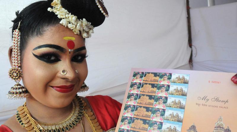 Anagha Sivadas, Kerala Nadanam participant, with the stamp set printed with her face.