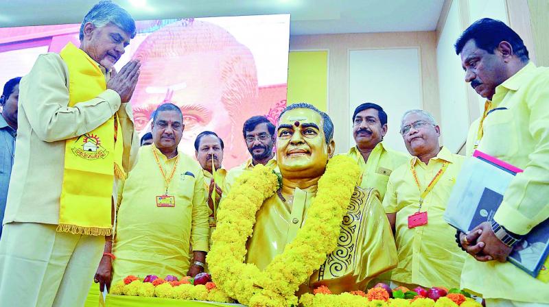 Chief Minister N. Chandrababu Naidu pays floral tributes to party founder N.T. Rama Raos portrait before the state level workshop at the CMs house in Vijayawada on Sunday. (Photo: DC)