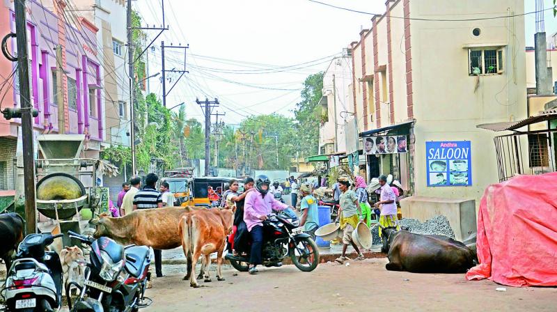 People have tough time to pass through an under construction road which was delayed for over a year, at Koyya Street in Visakhapatnam.