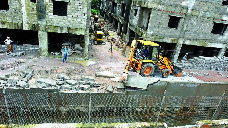 A JCB clears a road to widen a nala in the city. (Photo: DC)