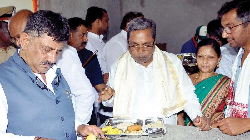 Energy Minister D.K. Shivakumar and Chief Minister Siddaramaiah have food at an Indira Canteen after launching it in Raichur on Tuesday.