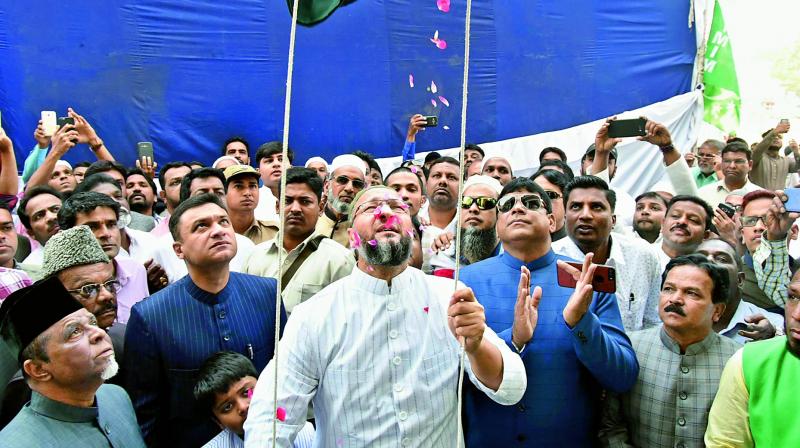 AIMIM president and Hyderabad MP Asaduddin Owaisi, along with his brother and party floor leader in the Telangana Legislative Assembly Akbaruddin Owaisi , hoists the party flag to Mark 60th formation day celebrations at Majlis headquarters Darussalam on Friday. (Photo: DC)