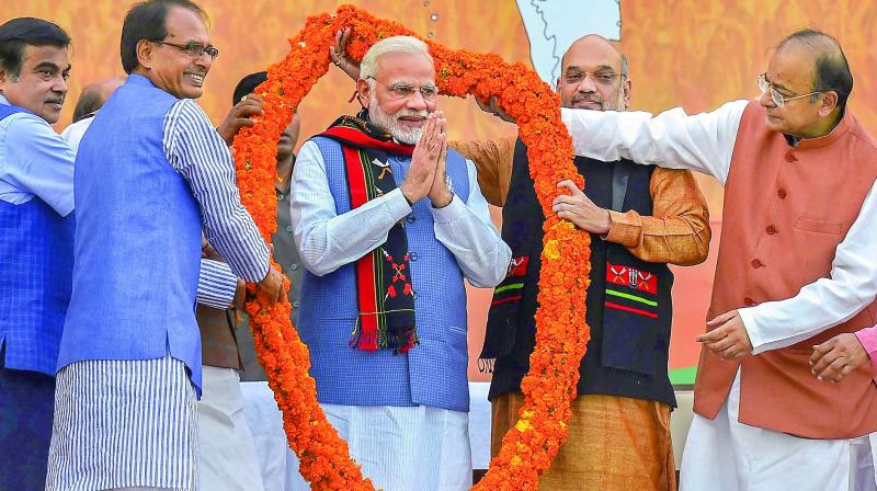 Party leaders felicitate Prime Minister Narendra Modi after their victory in North-East Assembly election at party headquarters in New Delhi on Saturday. (Photo: PTI)