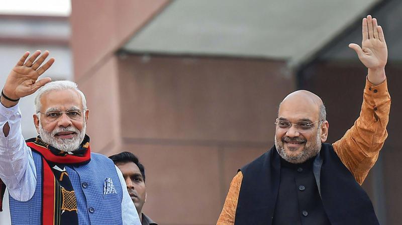 Prime Minister Narendra Modi and BJP president Amit Shah wave as they arrive to address BJP party workers after their victory in North-East Assembly election at party headquarters in New Delhi on Saturday. (Photo: PTI)