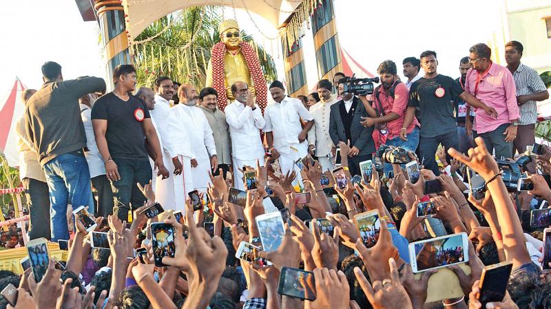 Superstar Rajinikanth greets his fans and audience at a function got up to unveil a statue of AIADMK founder and late Chief Minister M.G. Ramachandran at a private medical college here on Monday. Actors Prabhu, son of Sivaji Ganesan and Vijayakumar were among those from the film industry present on the occasion. (Photo: DC)