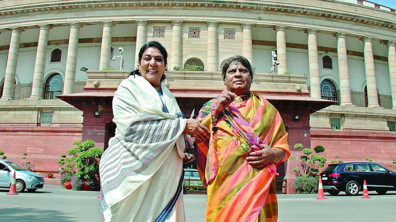 Congress MP Renuka Chowdhury shares a light moment with TD MP Shiva Prasad as he stages a protest in a sari against the NDA government demanding special category status for Andhra Pradesh, outside Parliament in New Delhi on Monday.