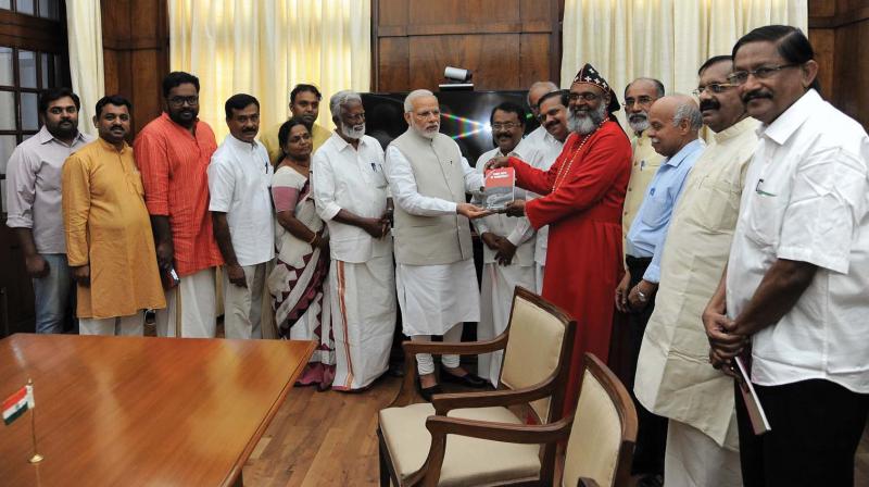 Prime Minister Narendra Modi releases P. S. Sreedharan Pillais book  Dark Days of Democracy by handing over a copy to Marthoma Delhi diocese head Gregorios Mar Stephanos Episcopa at Parliament on Wednesday.