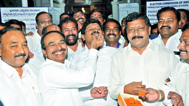 Telangana State finance minister Etela Rajender offers sweets to elected Rajya Sabha members from the TRS as they celebrate after announcement of celebration results in Hyderabad on Friday. (Photo: P. Surendra)