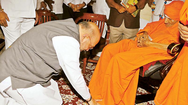 BJP national president Amit Shah seeks the blessings of the 110-year-old Sri Shivakumara Swami at Siddaganga Math in Tumakuru on Monday. (Photo: KPN)