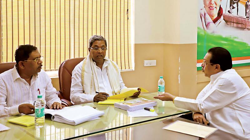 Chief Minister Siddaramaiah (centre) with KPCC president Dr G. Parameshwar and Minister M.R. Seetharam at the district presidents and the district in-charge ministers meeting, organised by the Karnataka Pradesh Congress Committee in Bengaluru on Wednesday. (Photo: DC)