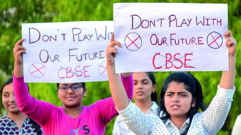Central Board of Secondary Education students display placards during a protest over the alleged paper leak, in Jabalpur on Friday. (Photo: PTI)