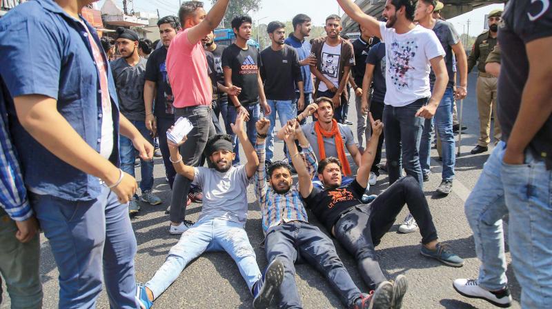 Students block a road during a protest against CBSE paper leak, in Jammu on Saturday. (Photo: PTI)