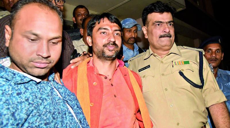 RSS leader Arijit Shashwat being taken away by police after his arrest, in Patna on Sunday. (Photo: PTI)