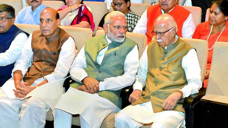 Prime Minister Narendra Modi interacts with senior BJP leader L.K. Advani as Union home minister Rajnath Singh looks on during BJP Parliamentary party meeting in New Delhi on Friday. (Photo: PTI)