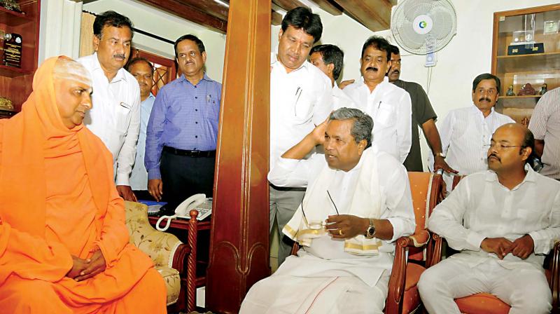 Chief Minister Siddaramaiah with Sri Shivaratrideshikendra Swami at Suttur Math in Mysuru on Friday. (Photo: KPN)