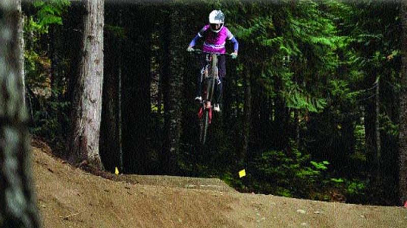 Anita Naidu performs a stunt on her mountain bike.