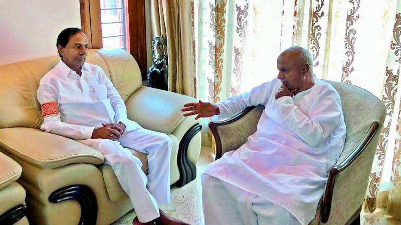 Chief Minister K. Chandrasekhar Rao and JD (S) chief Deve Gowda hold discussions during their meeting in Bengaluru on Friday.