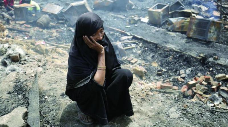 A woman sits at the site after an early morning fire gutted Rohingya camp in New Delhi on Sunday. (Photo: AP)