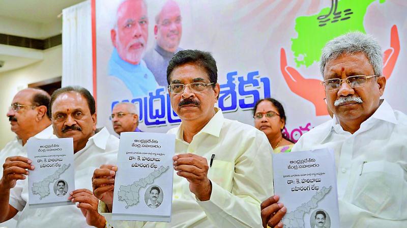 BJP state president and Vizag MP K Haribabu, MP Gokaraju Gangaraju and former minister P. Manikyala Rao release the book of  Central assistance to AP  in Vijayawada on Sunday. (Photo:DC)