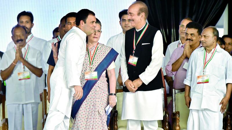 Congress President Rahul Gandhi hugs the former party president Sonia Gandhi as Ghulam Nabi Azad looks on during Jan Aakrosh Rally in New Delhi. (Photo: PTI)