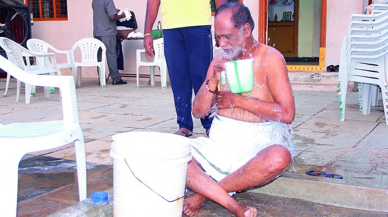 Dr. K. Laxman, BJP TS president takes a bath after spending the night at the home of Gowri Kumari a Dalit, in Aliabad village of Shameerpet- Medak district, as part of the Palle Nidra campaign.