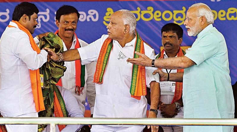 PM Narendra Modi pacifies state BJP president B.S. Yeddyurappa after an altercation on stage at the election rally at Santhemarahalli near Chamarajanagar on Tuesday. (Photo:AP)