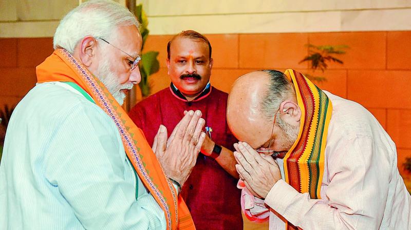Prime Minister Narendra Modi is greeted by BJP president Amit Shah in New Delhi on Tuesday. (Photo: PTI)